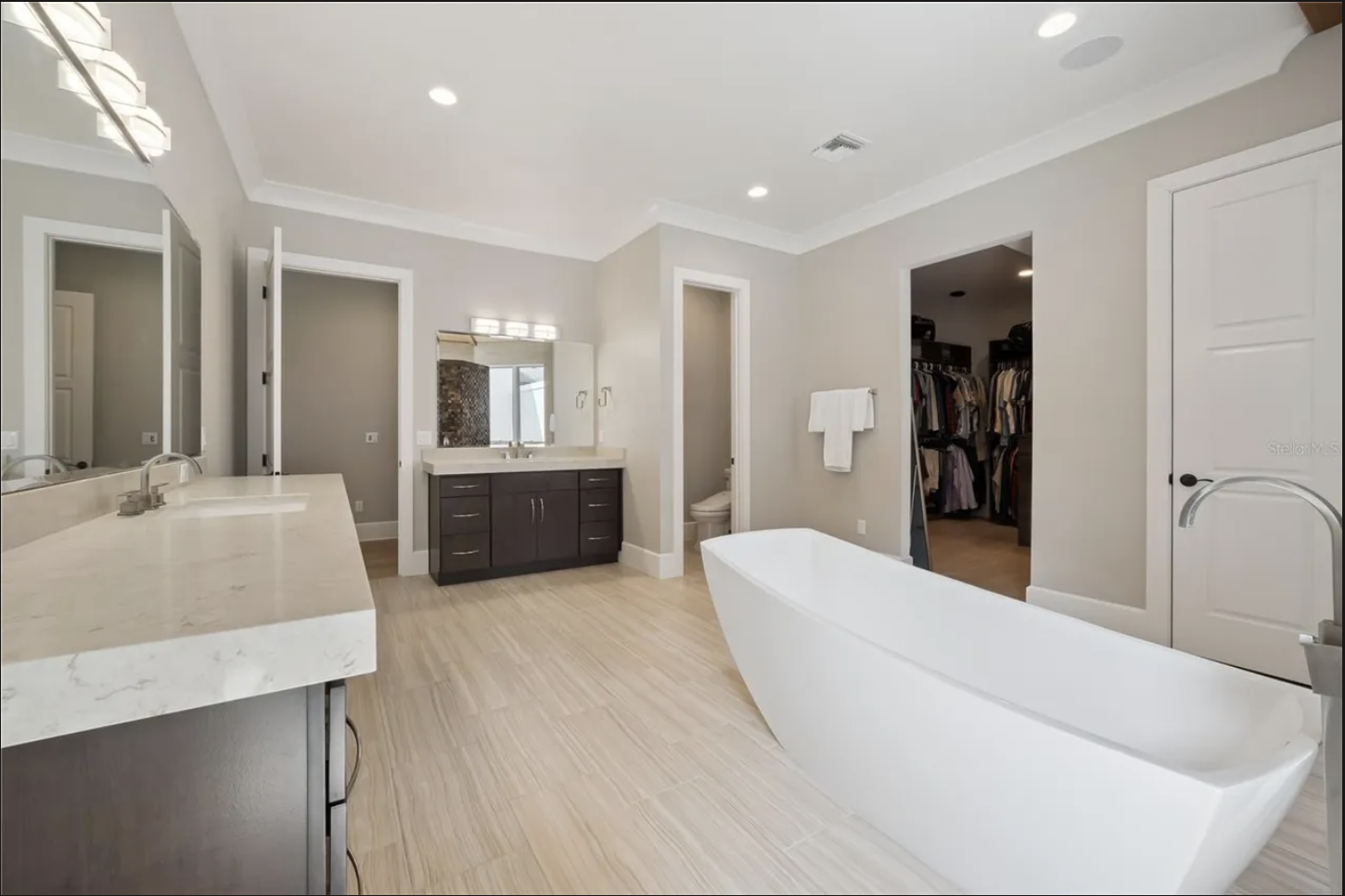 Primary bath with dual vanities and walk-in closet access
