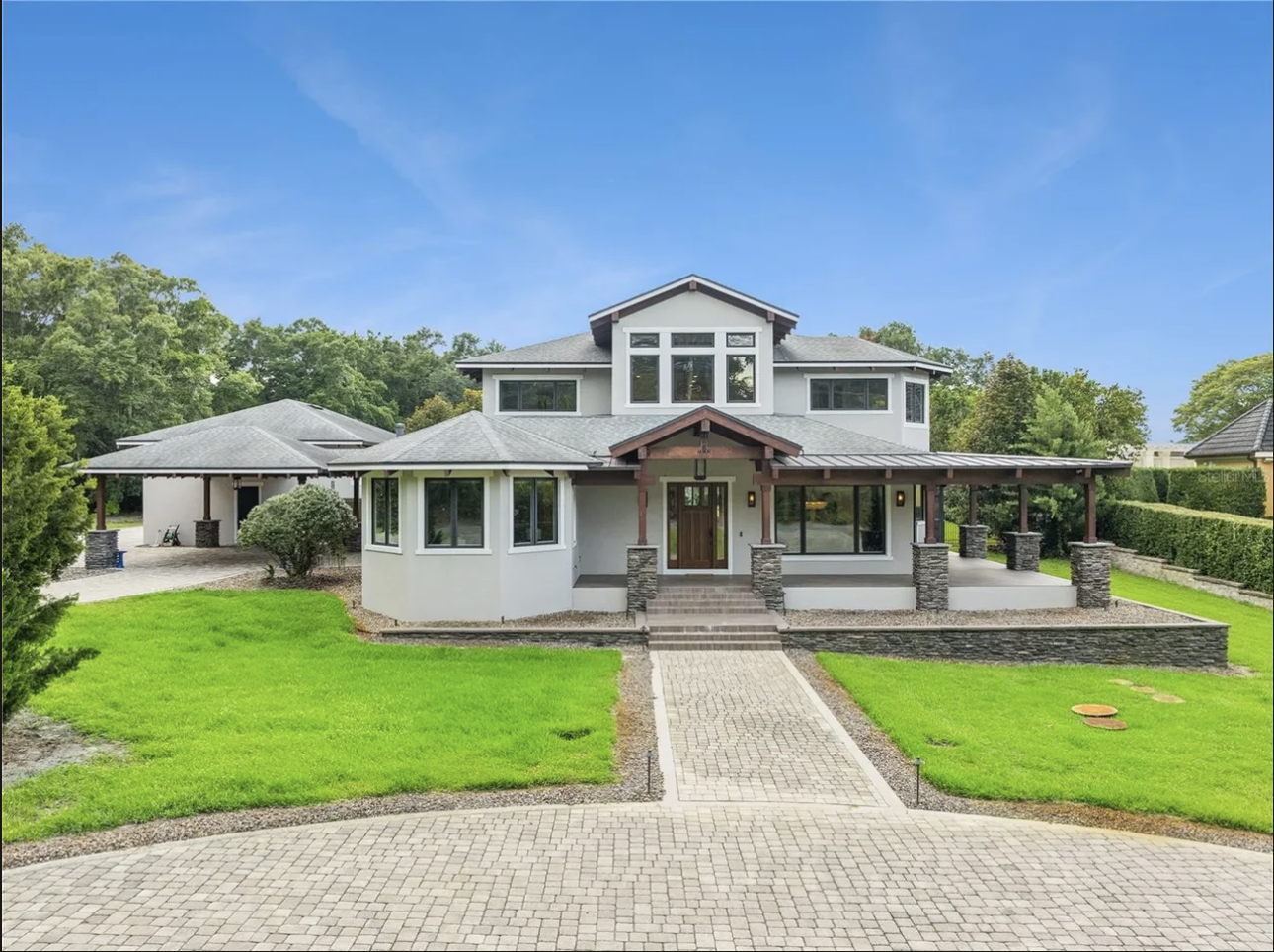 Wide front exterior view with circular paver drive