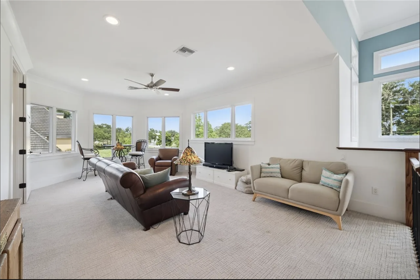 Upstairs bonus room with seating area and wall of windows